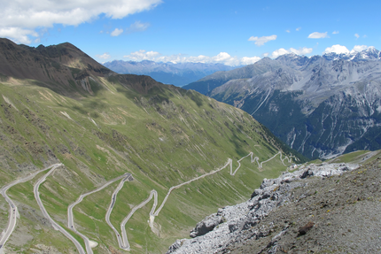 MoHo Schönauer Hof- Tour 12 Stilfserjoch Umbrail Serpentinenstraße in den Alpen bei klarem Himmel und Bergen im Hintergrund