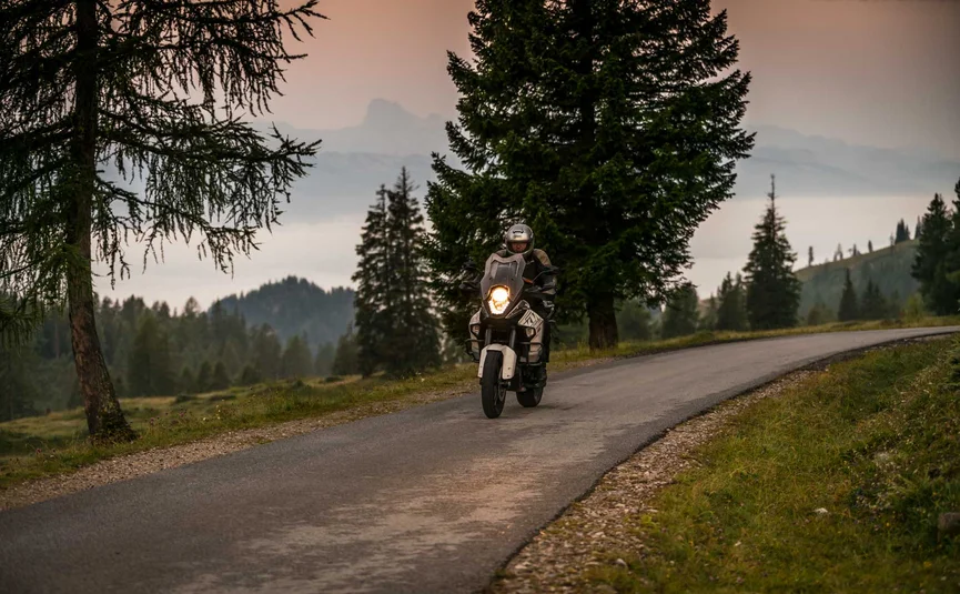 Almhotel & Genussgasthof Hierzegger ***S © Moppetfoto.de Motorcyclist on mountain road at dusk with trees and mountains