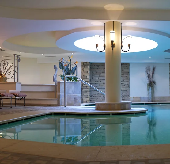 Indoor pool with lounge chairs and decorative stone wall