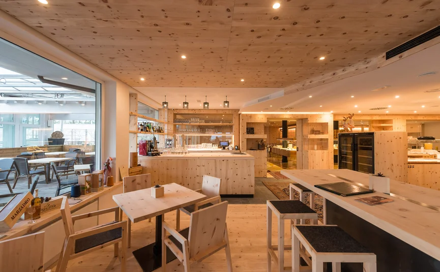 Cristallo Sport & Wellness Hotel **** © Andrea Acler Modern eingerichtetes Café mit Holzvertäfelung und Tageslicht