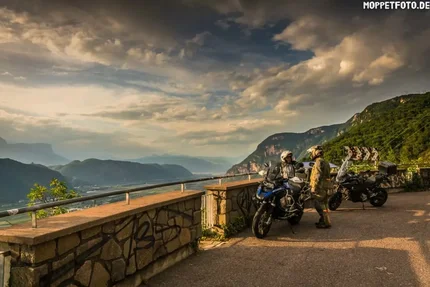 Biker mit Motorrädern auf Bergstraße bei Sonnenuntergang