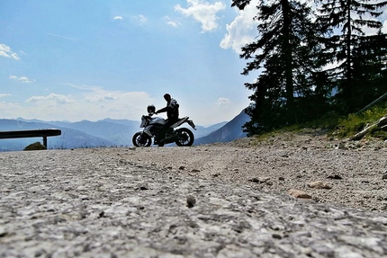 Motorradfahrer auf Bergstraße mit Bergen und Bäumen im Hintergrund
