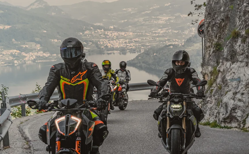 Cristallo Sport & Wellness Hotel **** © Andrea Acler Vier Motorradfahrer fahren auf bergiger Straße mit Seeblick