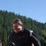 Motorradurlaub in Südtirol und den Dolomiten © Theiner Karl-Heinz & Co KG Mann steht neben weiß-blauer BMW HP2 Motorrad in sonniger Berglandschaft