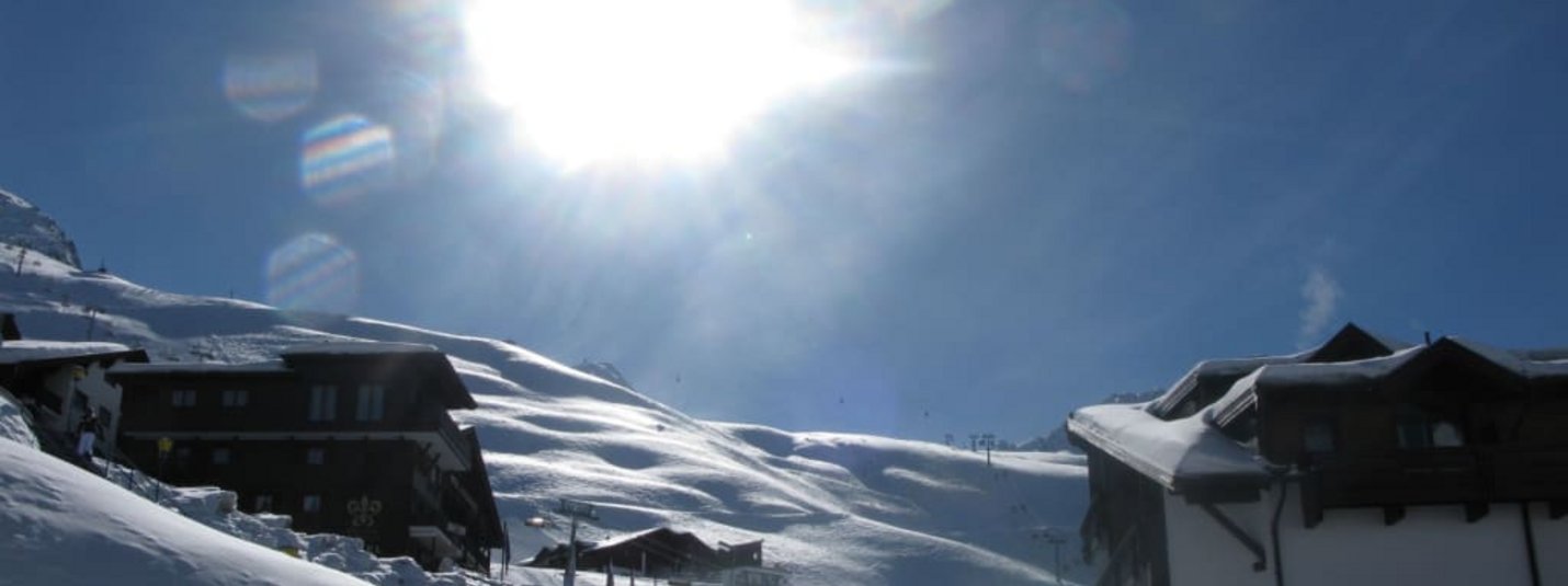 Sonniger Wintertag mit schneebedeckten Hütten in den Bergen