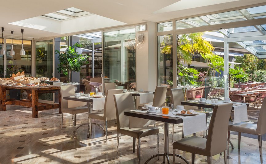 Bright breakfast room with set tables and buffet