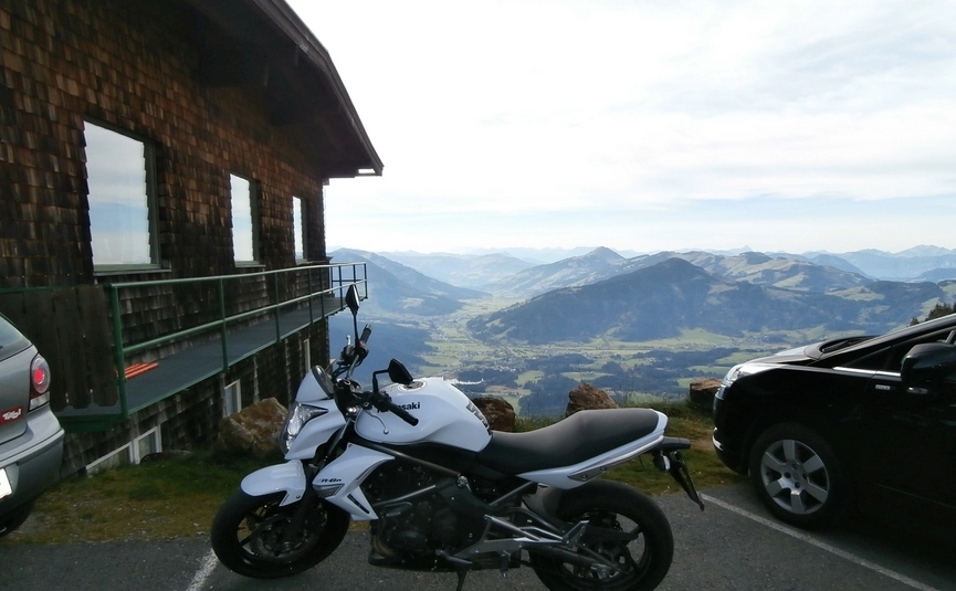 Kitzbüheler Horn Tour (Tour 7) Witte motor en auto's geparkeerd bij houten huis met uitzicht op bergvallei