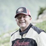 Motorradurlaub in Tirol © studio22.at - Marcel Hagen Lächelnder Mann mit Motorrad in Berglandschaft