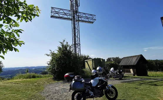 Motorradurlaub im Burgenland © Leberzipf Didi Motorräder vor einem großen metallischen Kreuz auf einem Hügel