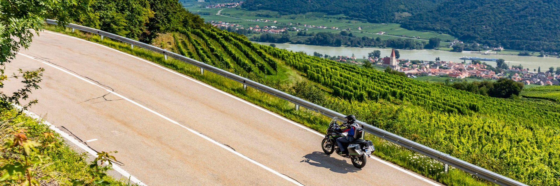 Gasthof Pension Drei Hacken *** © Alexander Seger Motorradfahrer auf kurviger Landstraße mit Weinbergen und Fluss im Hintergrund