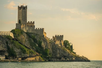 Castle on rocky cliff by the sea at sunset