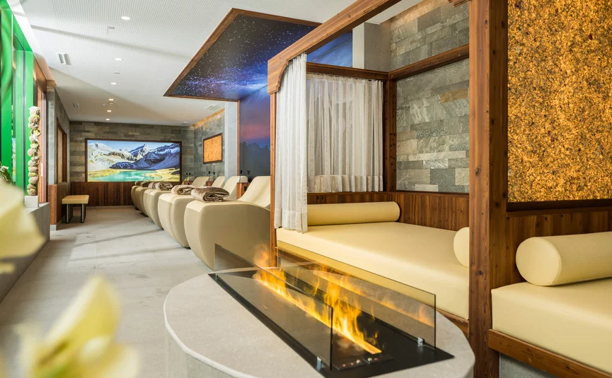 Modern relaxation room with loungers, fireplace, and mountain panorama image