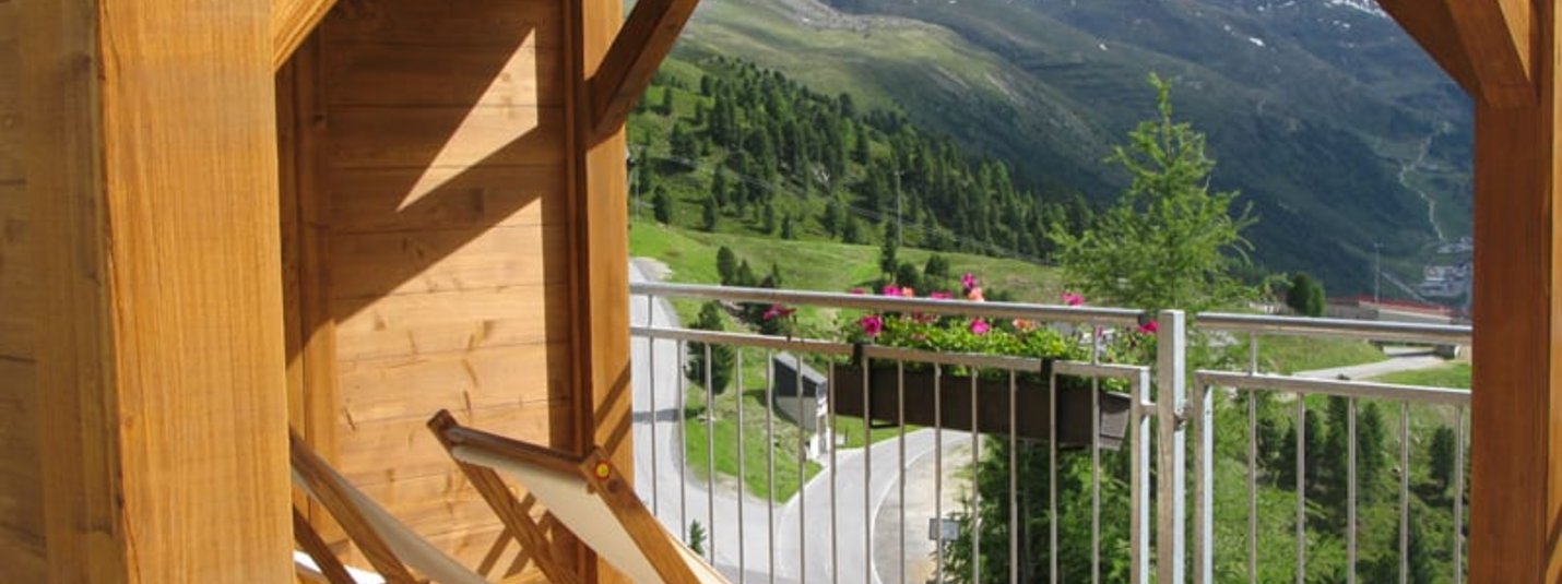 Premium 7 Tage Balkon mit Holzstühlen und Bergblick mit Schnee auf Gipfeln