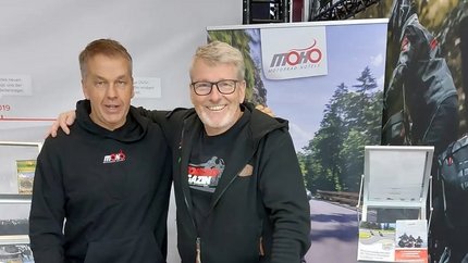 Zwei Männer an einem Messestand von MOHO Motorrad Hotels