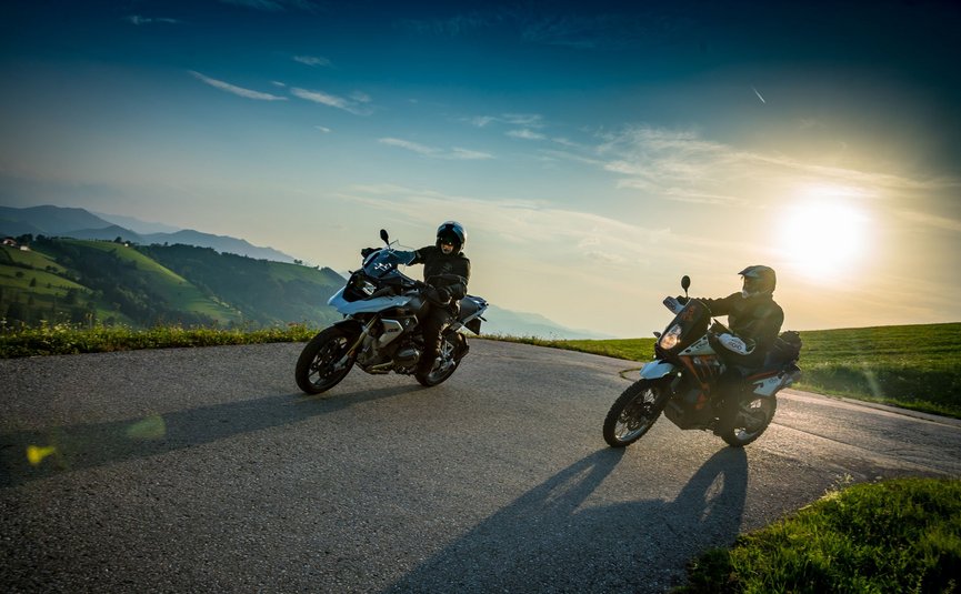 Motorradurlaub in Oberösterreich © Moppetfoto.de Zwei Motorradfahrer auf einem kurvigen Bergweg bei Sonnenuntergang