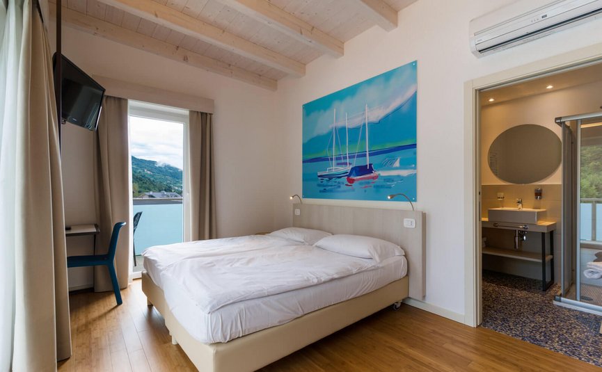 Helles Hotelzimmer mit Doppelbett, Balkon und angrenzendem Badezimmer