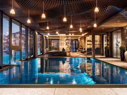 Elegantes Hallenbad mit Lounge, Panoramafenstern und hängenden Leuchten