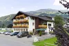 Sammelanfragen © Hotel Both Hotelgebäude mit Balkonblumen und Bergen im Hintergrund