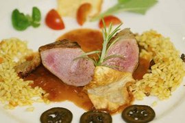 30 Jahre Jubiläums Bike Wochen Gourmetgericht mit rosa gebratenem Fleisch, Sauce, Reis und Gemüse auf weißem Teller