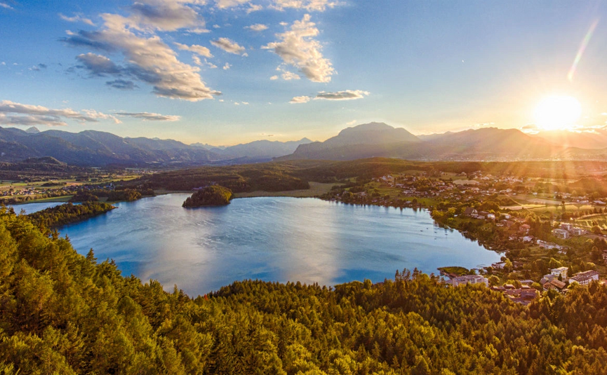 See mit Wald und Bergen bei Sonnenuntergang