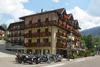 Sammelanfragen © Marisol s.n.c.di Pangrazzi Albino EC Mehrstöckiges Hotel mit Blumenbalkonen und Motorrädern davor an sonnigem Tag