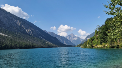 MOHo Tour 1 Allgäu Bregenzerwald Klarer Bergsee mit Bergen, Wald und blauem Himmel