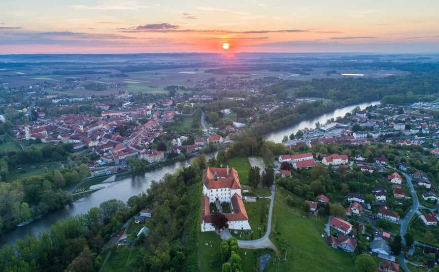 Luchtfoto van een stad met rivier en kasteel bij zonsondergang