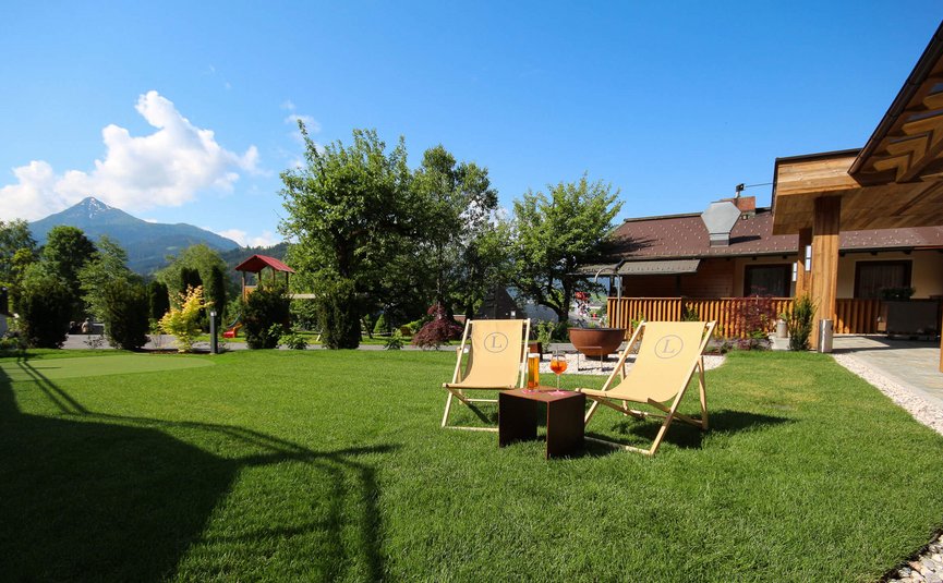 Garten mit Liegestühlen, Getränken und Berg im Hintergrund