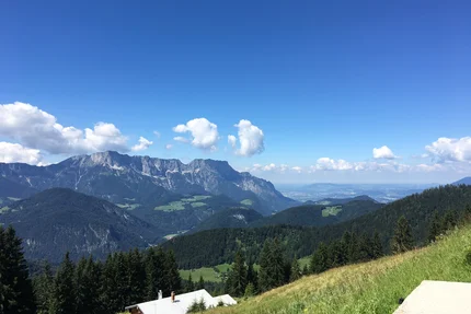 View of mountains, forest, and valley under a clear blue sky