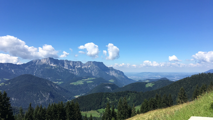 Blick auf Berge, Wald und Tal unter klarem blauem Himmel