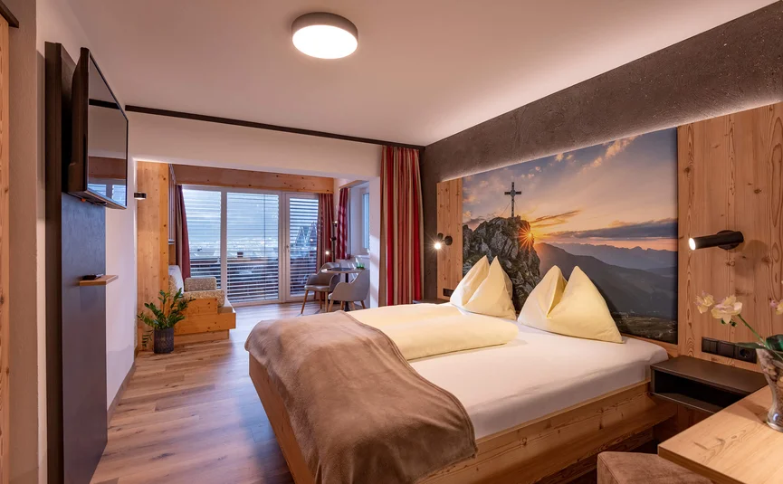 Cozy hotel room with double bed and mountain view wall art