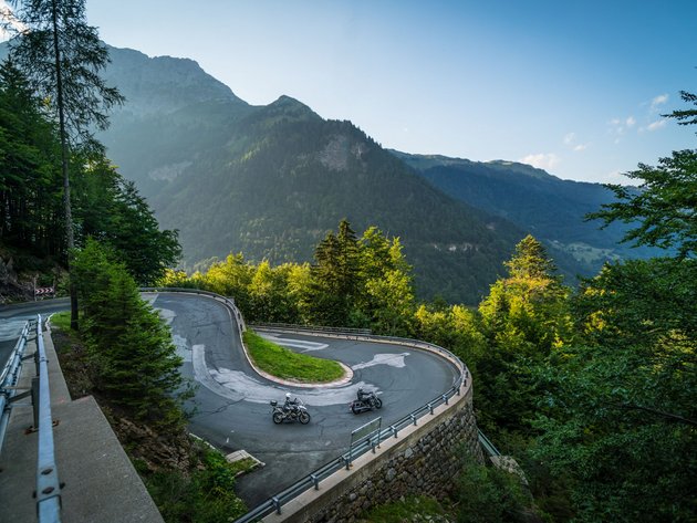 Qualitätsversprechen © Moppetfoto.de Enge Haarnadelkurve auf Bergstraße mit zwei Motorrädern