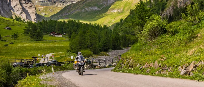 Mölltal – Großglockner – Nockalm © Alexander Seger Motorradfahrer auf Bergstraße mit schneebedeckten Alpen und grüner Landschaft