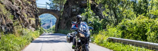 Motorradurlaub im Waldviertel © Alexander Seger Motorradfahrer fährt auf einer Straße durch eine felsige Landschaft mit Brücke