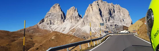 Bergstraße mit Felsen und Motorradhelm bei klarem Himmel