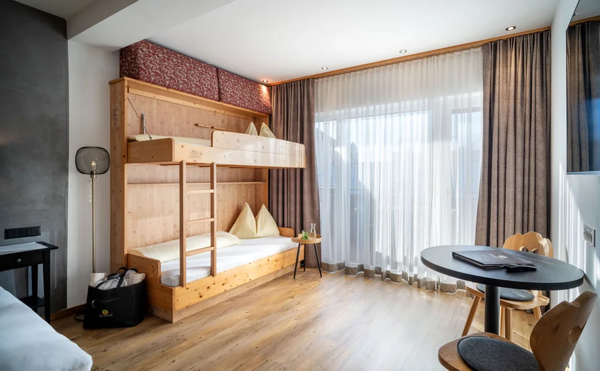 Bright room with bunk bed, curtains, and modern table with chairs