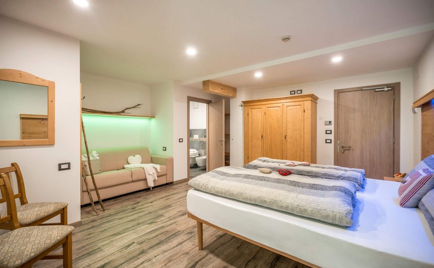 Albergo Panorama *** © Albergo Panorama Hell eingerichtetes Schlafzimmer mit Doppelbett, Sofa und Holzmöbeln