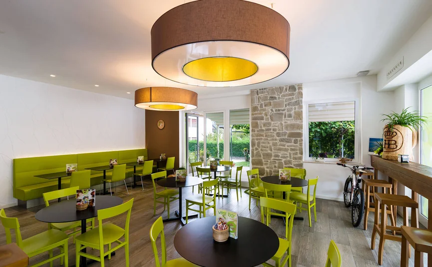 Modern café met groene stoelen en zwarte tafels binnen