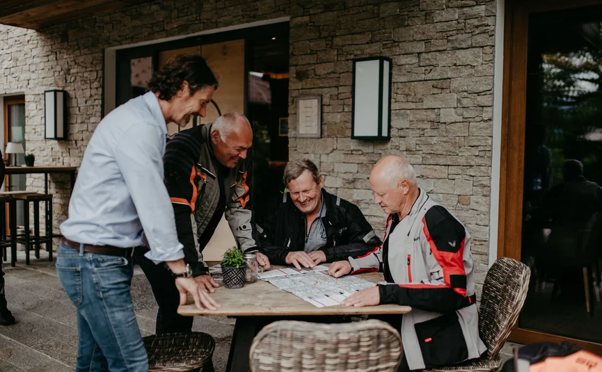 Landhotel & Gasthof Laudersbach *** Four men planning a trip using a map at an outdoor table