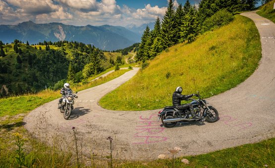 Motorradurlaub in Friaul – Karnien © Moppetfoto.de Motorradfahrer fahren auf kurvenreicher Bergstraße umgeben von grünen Hügeln