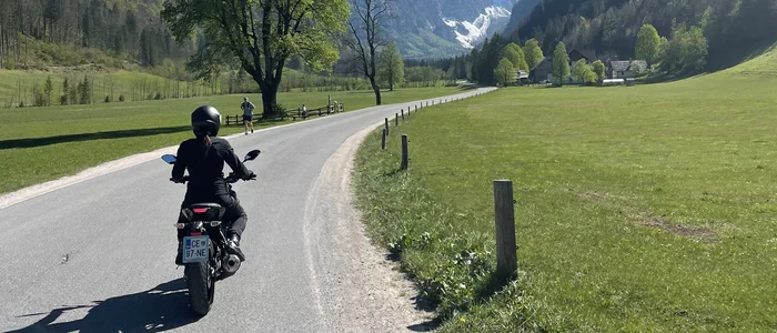 Savinja Tal © Hotel Grof Archive Motorradfahrer auf Straße mit Bergen und blauen Himmel im Hintergrund