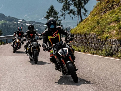 Valsugana – Kaiserjägerstraße © Andrea Acler Drei Motorräder fahren auf einer bergigen Straße mit Fahrern in Schutzkleidung
