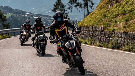 Trentino © Andrea Acler Drei Motorräder fahren auf einer bergigen Straße mit Fahrern in Schutzkleidung