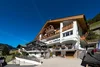 Sammelanfragen © Arik Oberrauch Hotel Florian mit Holzbalustraden und Blumen unter klarem blauem Himmel
