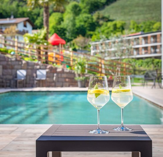 Zwei Gläser mit Zitronenlimonade am Pool bei sonnigem Wetter