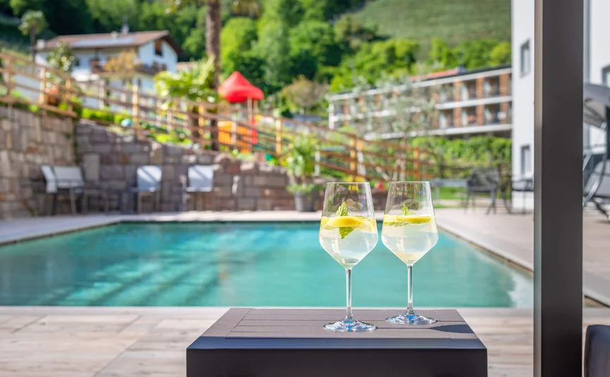 Two glasses of lemon drink by the pool on a sunny day