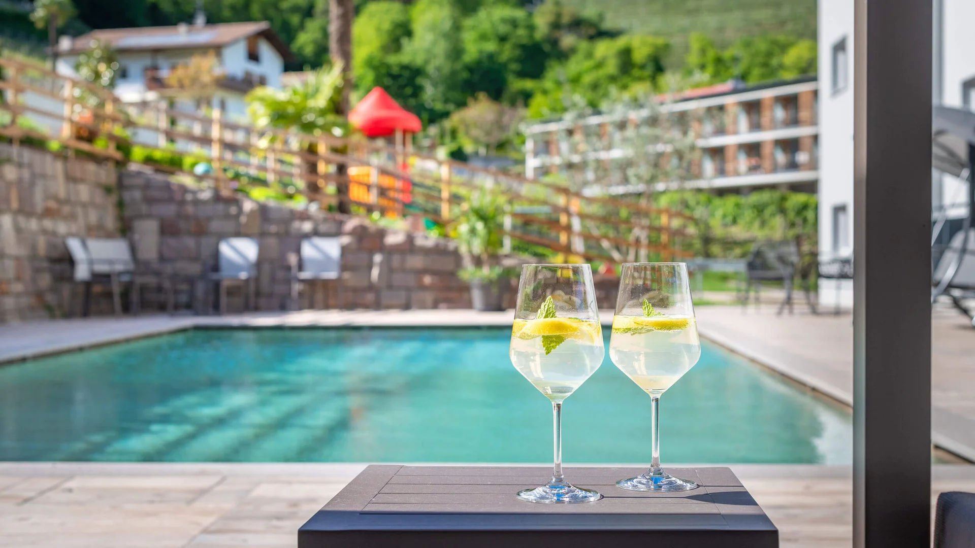 Two glasses of lemon drink by the pool on a sunny day