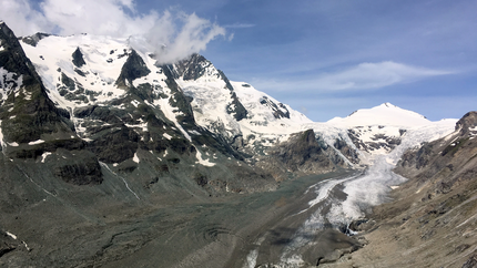 Schneebedeckte Berge mit schmelzendem Gletscher unter blauem Himmel