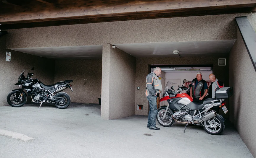 Bergseenrunde Drei Männer stehen neben Motorrädern in einer Garage