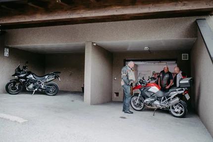Bergseenrunde Drei Männer stehen neben Motorrädern in einer Garage